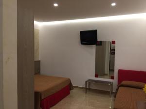 a bedroom with a bed and a tv on the wall at Suitedelmare in Gallipoli