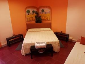 una camera con un letto e due tavolini con un comodino Sidx Sidx di Le Tre Sorelle B&b Garbatella a Roma