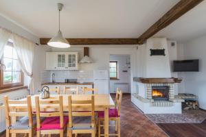 a kitchen and dining room with a table and a fireplace at Osada Pienińska in Krościenko