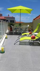 een patio met een tafel en een gele parasol bij Casa Violeta in Funchal