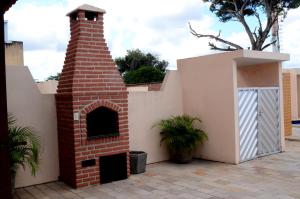 a brick fireplace next to a building with a door at Hotel Itaparica in Caruaru