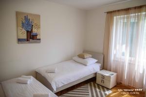 a small bedroom with two beds and a window at Apartment/Room ''Dalmacija'' SINJ in Sinj