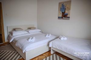 two beds in a room with white sheets at Apartment/Room ''Dalmacija'' SINJ in Sinj