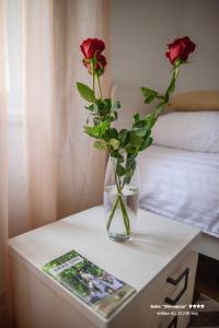 a vase with two roses sitting on a table at Apartment/Room ''Dalmacija'' SINJ in Sinj