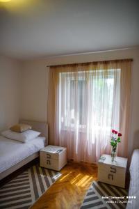 a bedroom with a bed and a window with flowers at Apartment/Room ''Dalmacija'' SINJ in Sinj