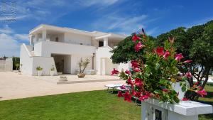 a white house with pink flowers in the yard at Case Vacanza Marzano in Monopoli