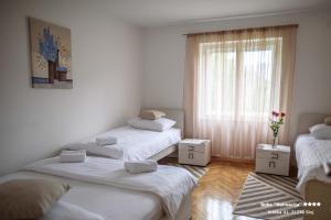 a room with three beds and a window at Apartment/Room ''Dalmacija'' SINJ in Sinj