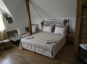 a bedroom with a large bed and a chair at Family Hotel Bellehouse in Chernomorets