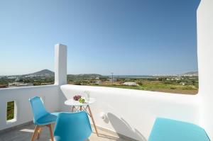 balkon z niebieskimi krzesłami i stołem z widokiem w obiekcie Naxian Spirit Suites & Apartments w mieście Agia Anna (Naxos)