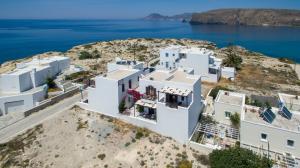 an aerial view of white buildings on a hill with the ocean at Niriides Studios in Pachaina