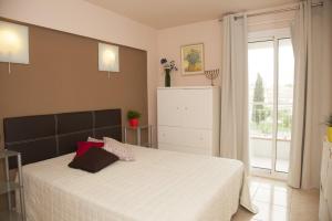 a bedroom with a large white bed with a window at Arogran II in Platja d'Aro