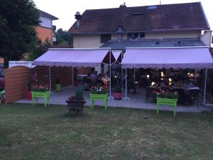 Tienda de campaña púrpura con mesas y sillas en un patio en Hôtel Le Bambi, en Baume-les-Dames