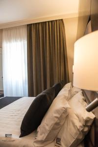 ein Schlafzimmer mit einem Bett mit Kissen und einem Fenster in der Unterkunft Porto Cesareo Exclusive Room in Porto Cesareo