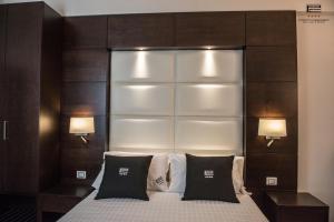 ein Schlafzimmer mit einem großen Bett mit zwei Lampen in der Unterkunft Porto Cesareo Exclusive Room in Porto Cesareo