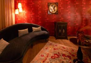 a living room with a couch and red wallpaper at Maison Au Cheval Noir in Maastricht