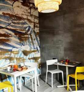 a dining room with two white tables and yellow chairs at Via Siracusa 5 in Castellammare del Golfo
