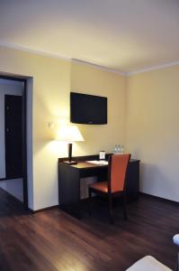 Habitación con escritorio con lámpara y silla. en Hotel Pojezierze, en Szczecinek