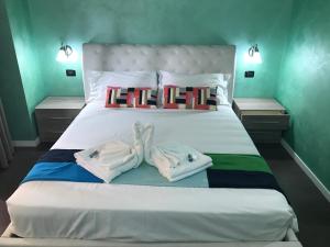 een slaapkamer met een bed met twee handdoeken erop bij B&B Roma in Rome