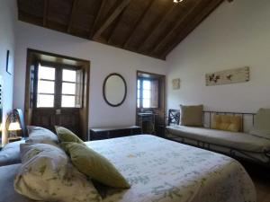 エルミグアにあるCasa Rural Llano Campoのベッドルーム(ベッド1台、ソファ付)