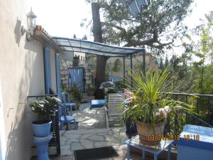un patio con sillas y una pérgola con plantas en Studio les murs en Vence