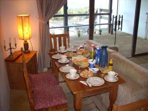 einen Tisch mit Speisen und Getränken im Wohnzimmer in der Unterkunft Homestay Tiradentes Alto da Torre in Tiradentes