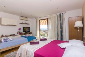 a bedroom with two beds and a window at Apartments Garmaz in Podgora