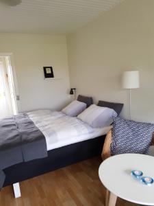 1 dormitorio con 1 cama grande y 1 mesa en Hammerknuden, en Allinge