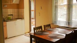 kuchnia z drewnianym stołem z 4 krzesłami i stolikiem w obiekcie Apartament Antique w mieście Karpacz