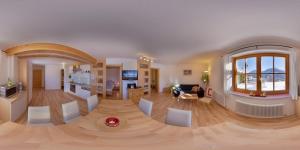 a large living room with a wooden floor and a kitchen at Appartements Hochegg in Schladming