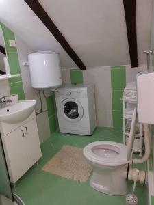 a bathroom with a toilet and a washing machine at Apartmani Kovačević in Kotor