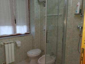 a bathroom with a toilet and a glass shower at Casa Vacanze Isabella in Aliano