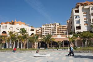 two people walking in a plaza in front of buildings at Jardín de Mariote Apartment in Almuñécar