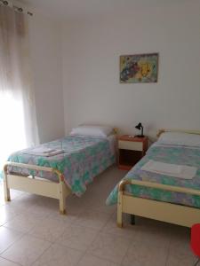 AlianoにあるCasa Vacanze Isabellaのベッドルーム1室(ベッド2台、窓付)