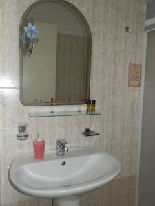 ein Waschbecken mit einem Spiegel und einer rosa Kerze in der Unterkunft Nanos Studios in Parga