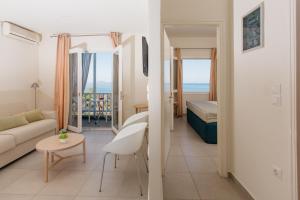 ein Wohnzimmer und ein Schlafzimmer mit einem Bett und einem Sofa in der Unterkunft Ikion Eco Boutique Hotel in Patitiri