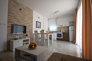 a kitchen and living room with a table with a bowl of fruit at Apartmani Kovačević in Kotor
