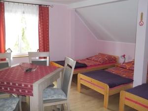 a room with two beds and a table and chairs at Apartamenty Stajni Jazon Malbork in Malbork