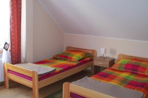 1 dormitorio con 2 camas y mesa con lámpara en Apartamenty Stajni Jazon Malbork, en Malbork