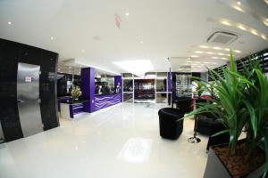 a salon with purple and white walls and plants at Holiday & Business Hotel - Em frente ao Centro de Eventos e Arena Conda in Chapecó