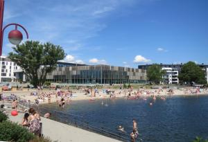 a group of people on a beach in the water at Apartment Holbergsgate in Kristiansand