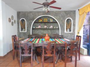 a dining room with a table with chairs and a ceiling fan at Posada Bugambilias in Catemaco