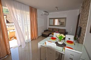 eine Küche und ein Wohnzimmer mit einem Tisch und Stühlen in der Unterkunft Apartmani Kovačević in Kotor