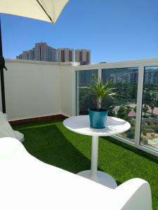 een witte tafel met een potplant op een balkon bij Apartamento Cala Finestrat in Benidorm