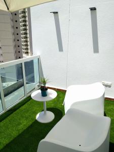 een kamer met een witte stoel en een tafel bij Apartamento Cala Finestrat in Benidorm