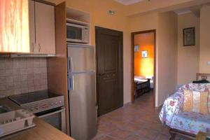 a kitchen with a stainless steel refrigerator and a microwave at Olympia Villas in Stoupa