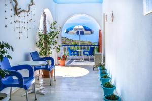 a hallway with blue chairs and a table with an umbrella at Villa George in Batsi