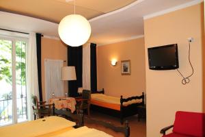 カズラノにあるOsteria Battelloの壁にテレビとベッドが備わる客室です。