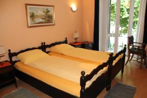 2 camas individuales en un dormitorio con ventana en Osteria Battello, en Caslano