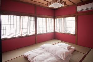 a room with a bed in a room with windows at Ninja TABI-NE in Kanazawa