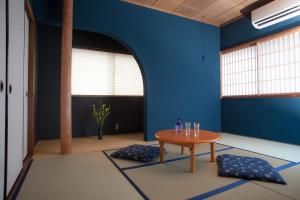 a room with a table and a blue wall at Ninja TABI-NE in Kanazawa